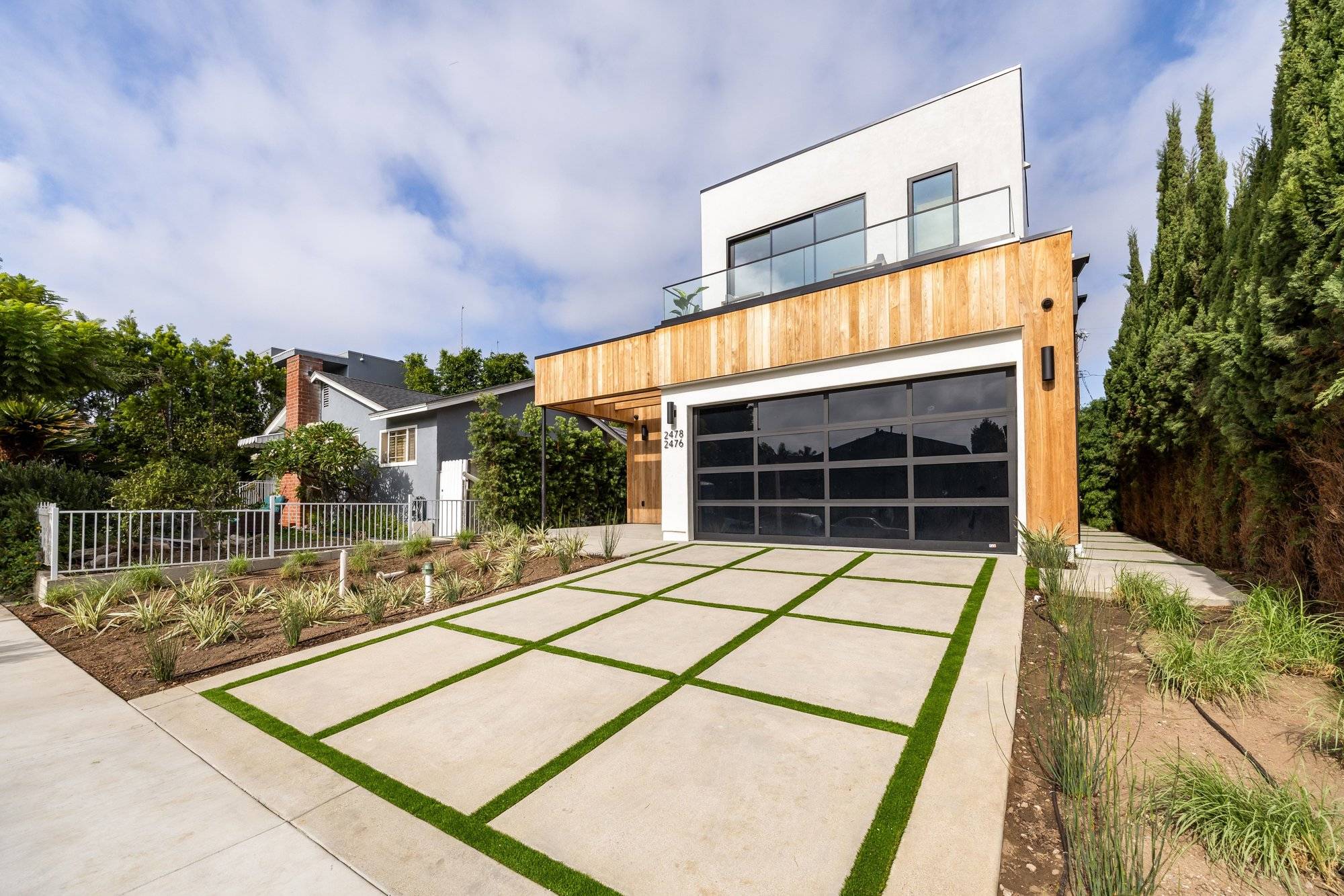 Front of 2478 Louella Ave, Venice: modern home with wood siding, glass balcony and two-car garage